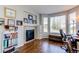 Bright office area with a fireplace, built-in shelving, a large bay window, and hardwood floors at 16590 Hitching Post Cir, Parker, CO 80134