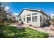 Home's backyard with brick patio and dining set adjacent to the house at 1374 Spotted Owl Way, Highlands Ranch, CO 80129