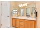 Bathroom featuring double sinks with wood cabinets and large mirror at 1374 Spotted Owl Way, Highlands Ranch, CO 80129