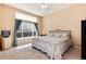 Cozy bedroom features a large window with curtains, plush carpet, and ceiling fan at 1374 Spotted Owl Way, Highlands Ranch, CO 80129