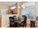 Cozy dining area featuring a dark wood table set and natural light from large windows with wood floors at 1374 Spotted Owl Way, Highlands Ranch, CO 80129
