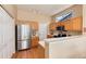 Well-lit kitchen with stainless steel appliances, wood cabinets, and a breakfast bar with wood floors at 1374 Spotted Owl Way, Highlands Ranch, CO 80129
