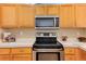 Updated kitchen featuring stainless steel appliances, light wood cabinets, and white countertops with wood floors at 1374 Spotted Owl Way, Highlands Ranch, CO 80129