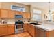 Updated kitchen with stainless steel appliances, light wood cabinets, and wood floors with breakfast bar at 1374 Spotted Owl Way, Highlands Ranch, CO 80129
