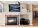 Close up shot of fireplace with a mantle, TV and decorative items in a neutrally painted open concept house at 1374 Spotted Owl Way, Highlands Ranch, CO 80129