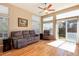 Bright living room with hardwood floors, neutral walls, a ceiling fan, and sliding glass doors to backyard at 1374 Spotted Owl Way, Highlands Ranch, CO 80129