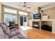 Inviting living room featuring a fireplace, large windows with backyard views, and comfortable seating at 1374 Spotted Owl Way, Highlands Ranch, CO 80129