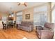 Spacious living room with hardwood floors, comfortable furniture, and a view of the dining area and kitchen at 1374 Spotted Owl Way, Highlands Ranch, CO 80129