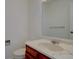 Bright bathroom featuring a cherry-stained vanity, a marbled countertop, and a large mirror at 13901 E Oxford Pl, Aurora, CO 80014