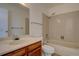 Bathroom featuring a single sink vanity, toilet, and bathtub-shower combo at 13901 E Oxford Pl, Aurora, CO 80014