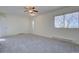 This spacious bedroom features plush gray carpet, two windows, and baseboard heaters at 13901 E Oxford Pl, Aurora, CO 80014