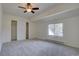 Bright bedroom featuring plush carpet, a ceiling fan, and a closet at 13901 E Oxford Pl, Aurora, CO 80014