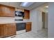 Functional kitchen space with tile flooring, wooden cabinets, and access to a laundry area with laundry machines at 13901 E Oxford Pl, Aurora, CO 80014