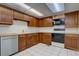 The kitchen boasts wood cabinets, a dishwasher, tiled floors, and essential appliances for a functional cooking space at 13901 E Oxford Pl, Aurora, CO 80014