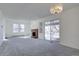 Open living space with carpet, a fireplace, large windows, and a sliding glass door that brings ample natural light into the room at 13901 E Oxford Pl, Aurora, CO 80014