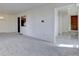 Spacious living room with neutral carpet, an open floor plan, and an entryway that leads to the front entrance and kitchen at 13901 E Oxford Pl, Aurora, CO 80014