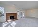 Bright living room featuring neutral carpet, a brick fireplace, and sliding glass doors that offer natural light and backyard access at 13901 E Oxford Pl, Aurora, CO 80014