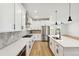 Modern kitchen with white cabinets, herringbone backsplash, and large island at 42974 Colonial Trl, Elizabeth, CO 80107