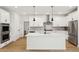 Modern kitchen with white cabinets, herringbone backsplash, and large island at 42974 Colonial Trl, Elizabeth, CO 80107