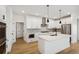 Modern kitchen with white cabinets, herringbone backsplash, and large island at 42974 Colonial Trl, Elizabeth, CO 80107