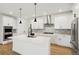 Modern kitchen with white cabinets, herringbone backsplash, and large island at 42974 Colonial Trl, Elizabeth, CO 80107