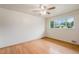 Bright bedroom features hardwood floors, ceiling fan, and a large window with neighborhood views at 260 Flint Way, Broomfield, CO 80020