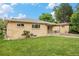 Charming brick home features a well-manicured lawn, flower bushes, and classic architectural details at 260 Flint Way, Broomfield, CO 80020