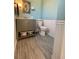 Well lit bathroom with green vanity, stylish tile floors, and updated fixtures at 6585 W 84Th Way # 109, Arvada, CO 80003