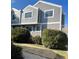 Exterior view of a townhouse featuring gray siding, white trim, and trimmed shrubbery in the front yard at 6585 W 84Th Way # 109, Arvada, CO 80003