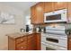 Modern kitchen featuring granite countertops, wood cabinetry, and white appliances at 3311 S Logan St, Englewood, CO 80113