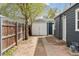 View of the home's backyard and detached garage with privacy fence at 3740 W 54Th Ave, Denver, CO 80221
