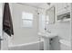 Bright white bathroom with a classic pedestal sink, subway tile, and a shower/tub combo at 3740 W 54Th Ave, Denver, CO 80221