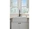 Close-up of a farmhouse sink with matte black hardware and natural light from dual windows at 3740 W 54Th Ave, Denver, CO 80221