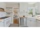 Bright kitchen featuring a farmhouse sink, stainless steel appliances, and a view into the living area at 3740 W 54Th Ave, Denver, CO 80221