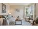 Bright living room features a plush sofa, side chairs, and natural light from bay windows at 3740 W 54Th Ave, Denver, CO 80221