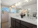 Bright bathroom with double sinks, dark cabinets, and decorative wall mirror at 845 Eudora St, Denver, CO 80220