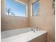 A luxurious tub beneath two bright windows in neutral tones at 845 Eudora St, Denver, CO 80220