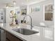 Modern kitchen sink island featuring stainless faucet, quartz countertops and views into living room at 845 Eudora St, Denver, CO 80220