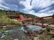 Picturesque view of the Argo Mill and a scenic bridge spanning a rocky riverbed under a cloudy sky at 1716 Virginia St, Idaho Springs, CO 80452