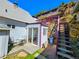 Backyard view featuring a sliding glass door to sunroom, patio seating area, and upper hillside with access stairs at 1716 Virginia St, Idaho Springs, CO 80452