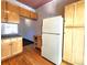 Functional kitchen with wood cabinets and white refrigerator at 1716 Virginia St, Idaho Springs, CO 80452