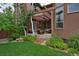 Lush backyard featuring a covered patio area and beautifully landscaped garden at 8044 E 24Th Ave, Denver, CO 80238