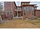 Expansive backyard with a patio, lush landscaping, and multi-story home view at 8044 E 24Th Ave, Denver, CO 80238