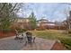 A patio set sits on a brick patio in the backyard of this home with a well-maintained lawn at 8044 E 24Th Ave, Denver, CO 80238