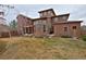 A view of the back of the home with a large lawn and manicured landscaping at 8044 E 24Th Ave, Denver, CO 80238