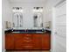 Bathroom featuring double vanity with framed mirrors and dark cabinets at 8044 E 24Th Ave, Denver, CO 80238