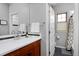 Clean bathroom features a wood vanity, a large mirror, and a shower/tub combo at 8044 E 24Th Ave, Denver, CO 80238