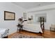 Cozy bedroom with hardwood floors, a plush bed, and ample natural light from the window at 8044 E 24Th Ave, Denver, CO 80238
