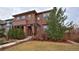 Charming two-story home with a brick and stucco facade and a well-manicured front yard with mature trees at 8044 E 24Th Ave, Denver, CO 80238