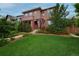 Beautiful townhome featuring lush green grass and mature landscaping at 8044 E 24Th Ave, Denver, CO 80238